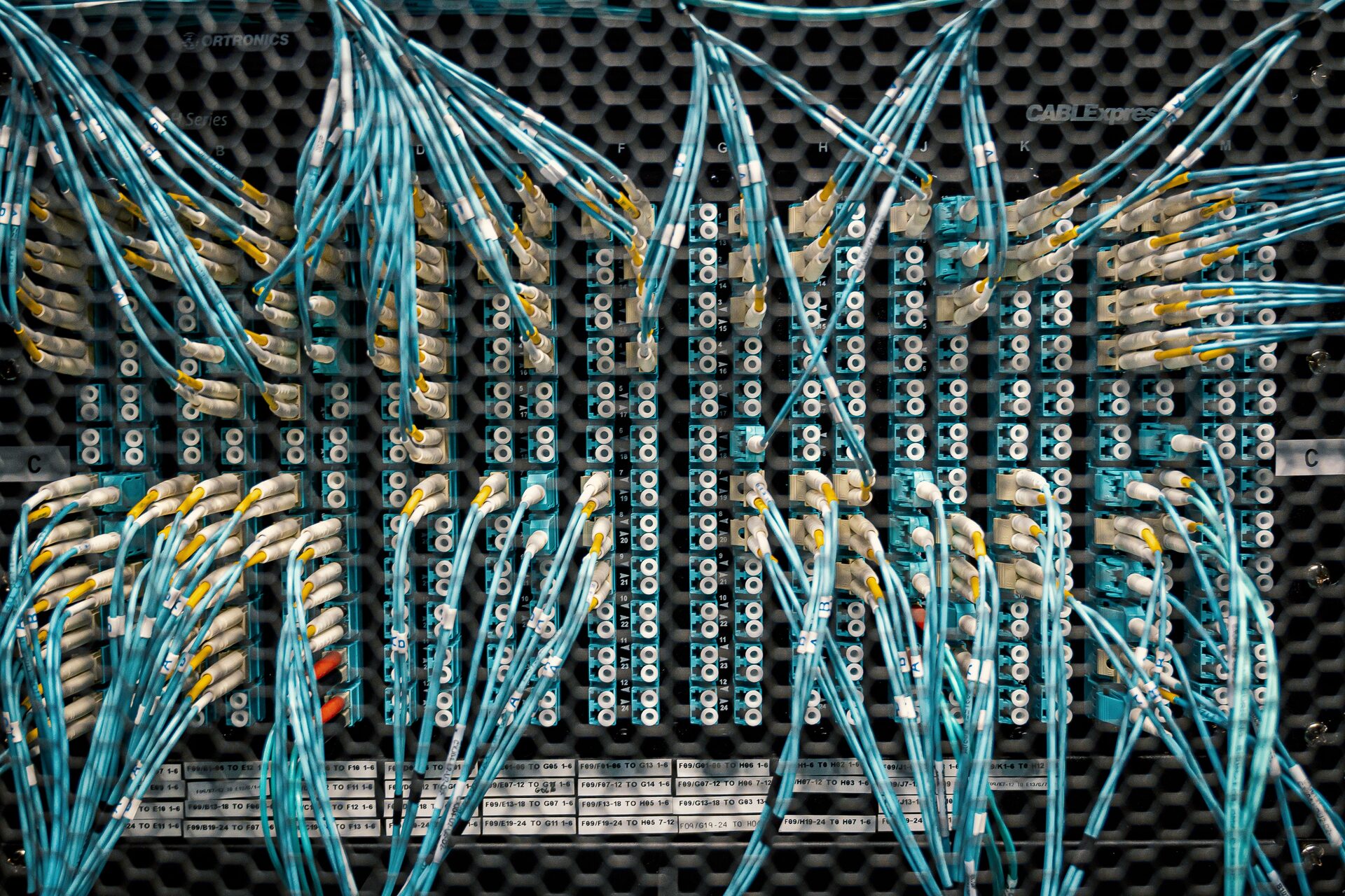 Close-up of fiber optic cabling and patch panels inside a data center server rack