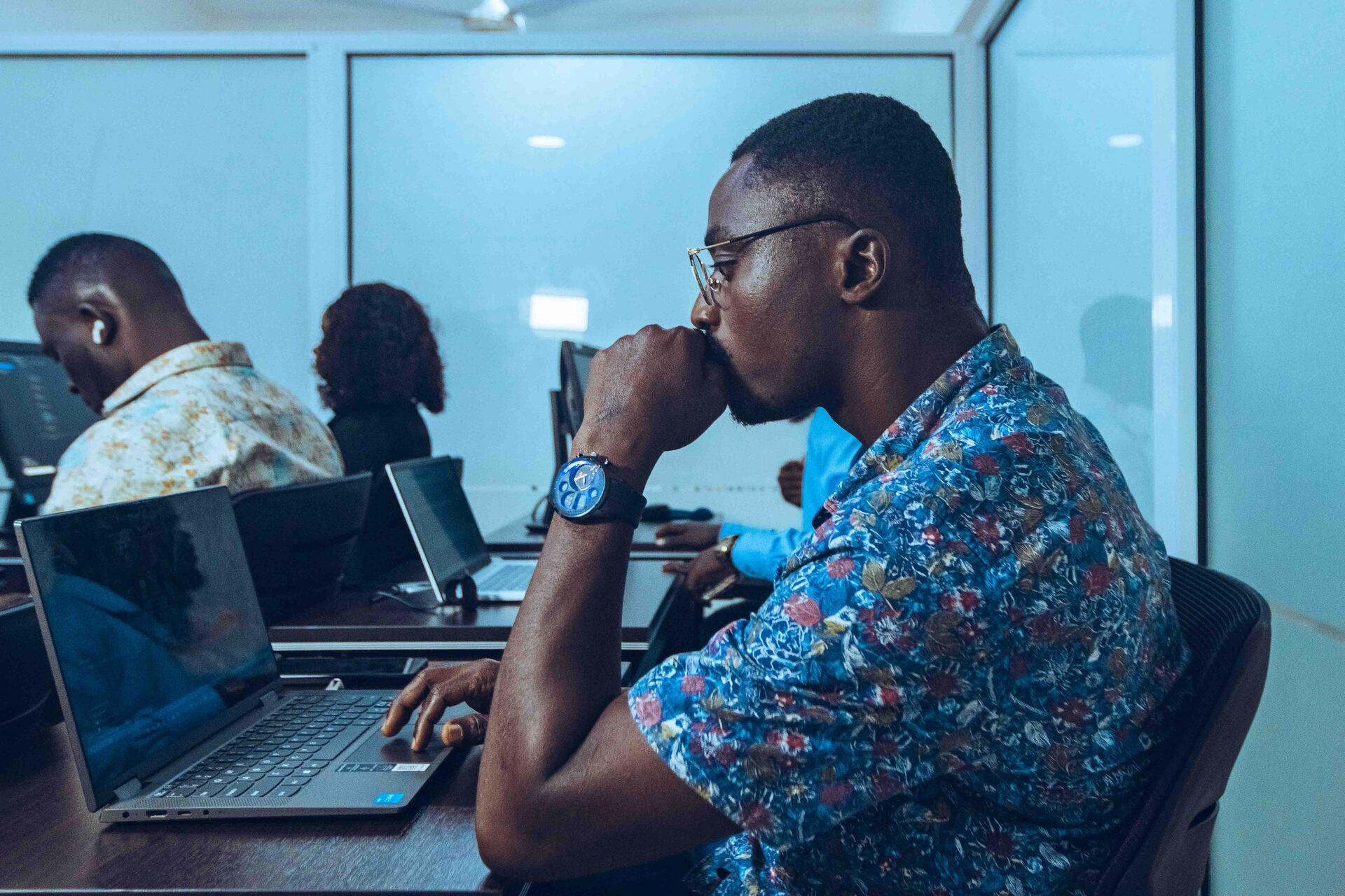 A working professional using AI tools at a laptop in a modern office